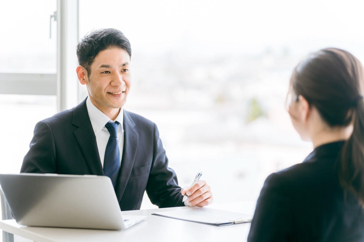 資料を示しながら説明する担当者と話を聞く従業員